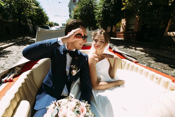 Casal jovem elegante no carro vermelho — Fotografia de Stock