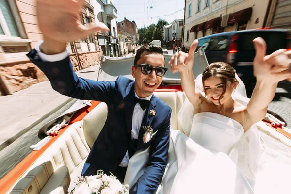 Casal feliz no carro no dia do casamento — Fotografia de Stock