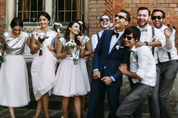 Glimlach van de bruidegom met de bruidsmeisjes en groomsmen — Stockfoto