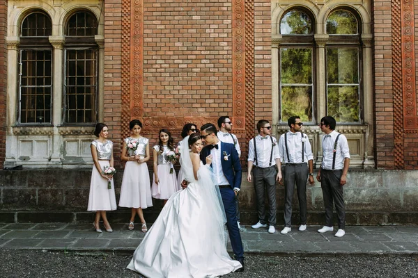 Mooie paar en bruidsmeisjes met groomsmen achter — Stockfoto