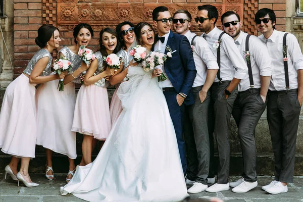 Jong (echt) paar met de grappige vrienden op de bruiloft — Stockfoto