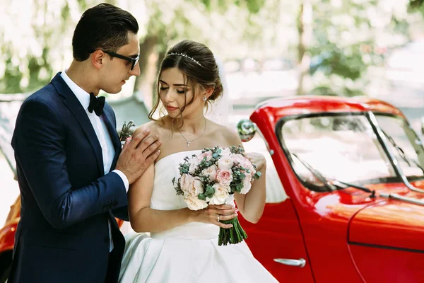 Bruidegom staat naast zijn schattige bruid — Stockfoto