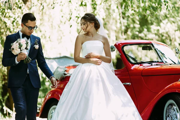 Невеста в платье и жених с букетом — стоковое фото