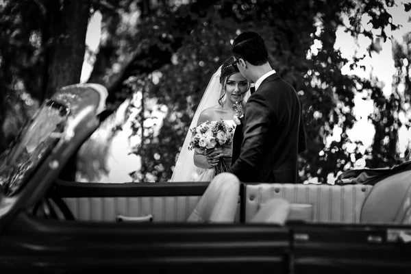 Sguardo della sposa con un bouquet accanto allo sposo — Foto Stock