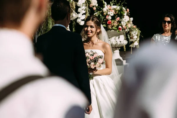 Noiva feliz com um buquê na cerimônia de casamento — Fotografia de Stock