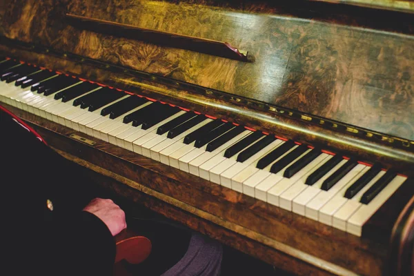 Man sits at an  vintage piano — Stock Photo, Image