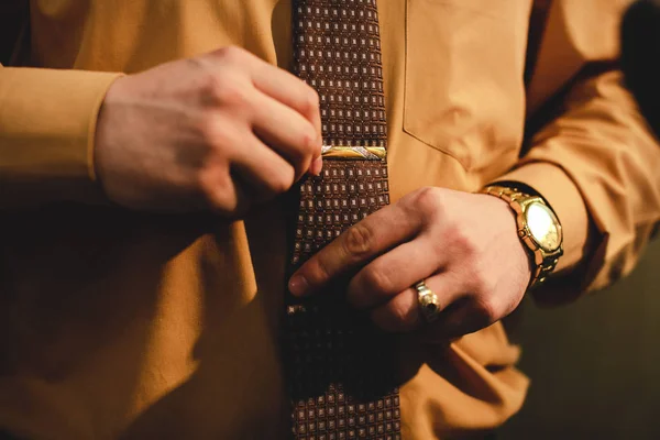 Hombre con reloj ajusta una corbata — Foto de Stock