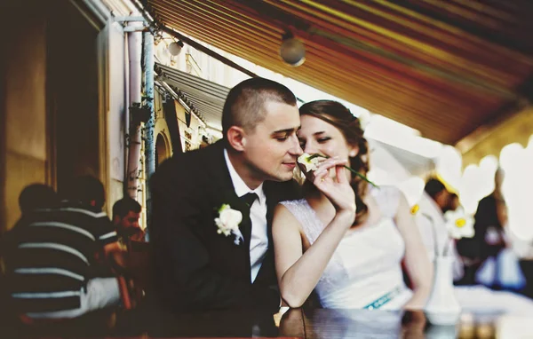 Novio huele una flor en la mano de la novia mientras descansan en un s — Foto de Stock