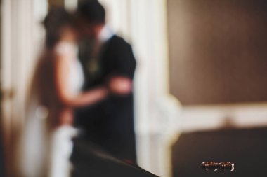 Alyans yalan siyah piyano üzerinde yeni evliler öpücük iken