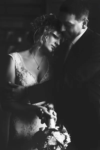 A black and white picture of a groom hugging a thoughtful bride — Stock Photo, Image