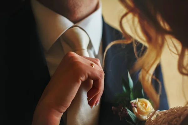Наречена коригує білу краватку нареченого перед весіллям — стокове фото