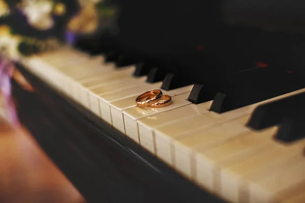 Obrączki ślubne leżą na klawiszach fortepianu — Zdjęcie stockowe