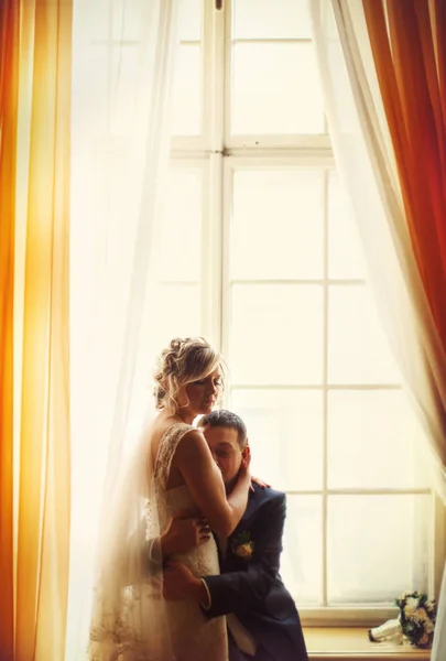 Ein zärtlicher Moment zwischen Braut und Bräutigam, während sie seine Hand drückt — Stockfoto