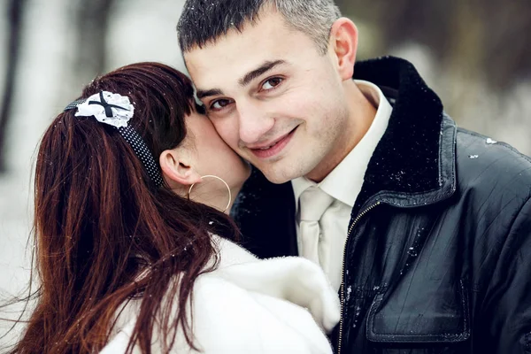 Een knappe bruidegom glimlacht terwijl een bruid verbergt haar gezicht onder zijn c — Stockfoto