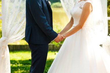 Gelinler düğün kemer yakınındaki ellerini tutun