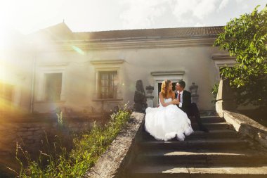 Güneş parlar altında eski taş üzerine oturan bir evlilik çift ayak