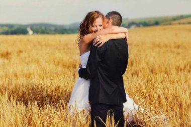 Bir damat ve mutlu çekici gelin sarılma arkadan bir görünüm