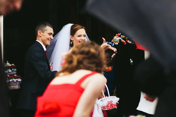 Noiva e noivo através de doces longe para os convidados — Fotografia de Stock