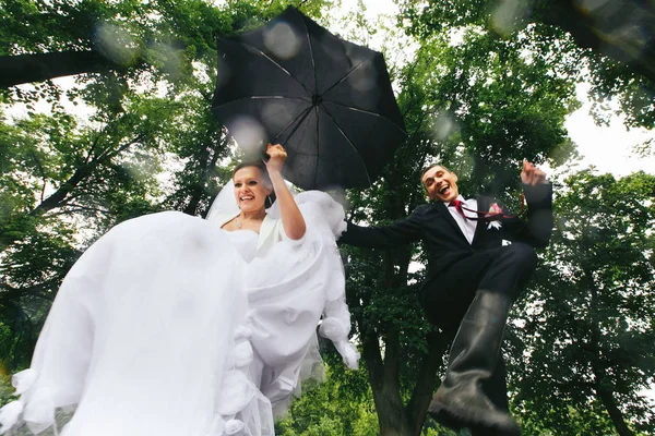 Recém-casados se divertem pulando em piscinas — Fotografia de Stock