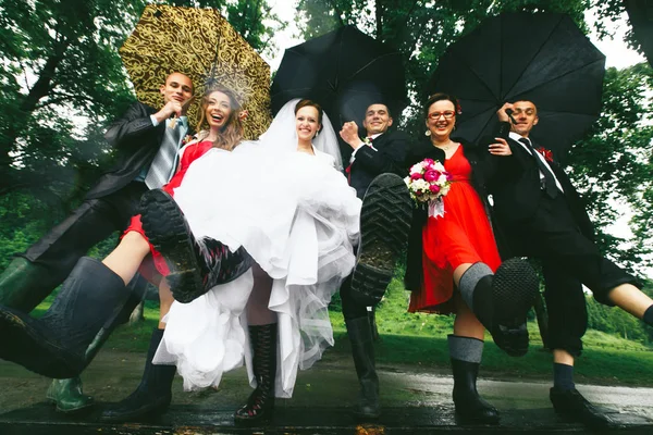 Jonggehuwden en hun vrienden ophouden benen in de gumboots — Stockfoto