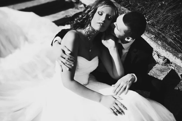 Solen lyser upp brudens ansikte medan hon och fästman sitter på sto — Stockfoto