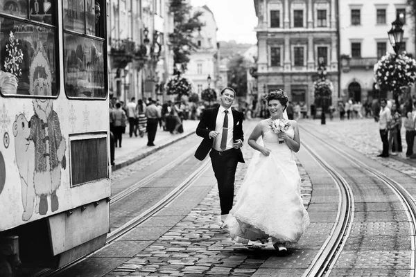 Joyful recém-casados tentar pegar um bonde — Fotografia de Stock