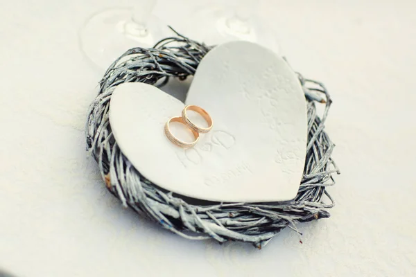 Snubní prsteny ležet na plechu ve tvaru srdce — Stock fotografie