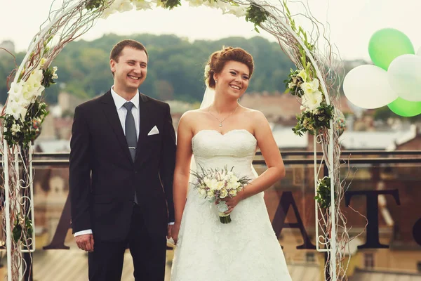 Жених и невеста смеются стоя под алтарем — стоковое фото