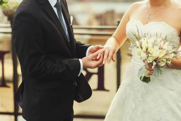 Bruidegom zet een trouwring op Bruidskamer tedere hand — Stockfoto