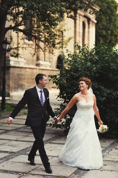 Ein Hochzeitspaar spaziert durch eine alte Stadt — Stockfoto