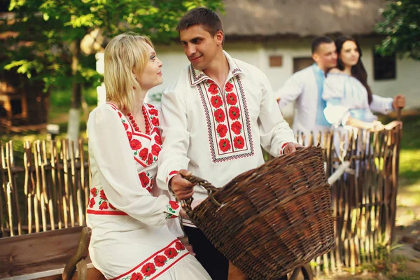 Couples standing behind an old Ukrainian house — Stock Photo, Image