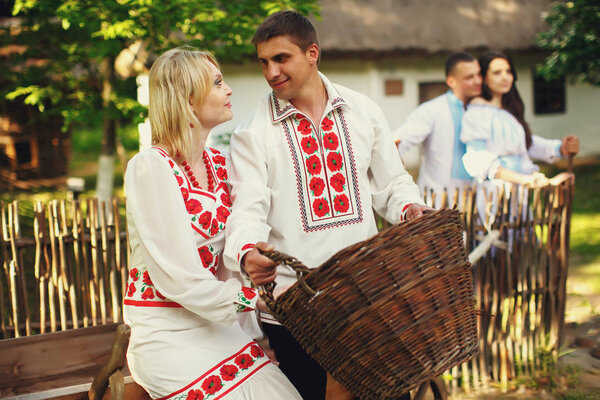 couples standing behind an old Ukrainian house 