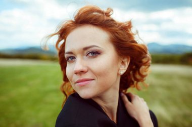 Süre h Rüzgar esiyor bayan kırmızı kıvırcık saçlı çarpıcı görünüyor