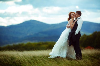 Büyük bir dağ ile sahada ayakta damat gelin eğilir