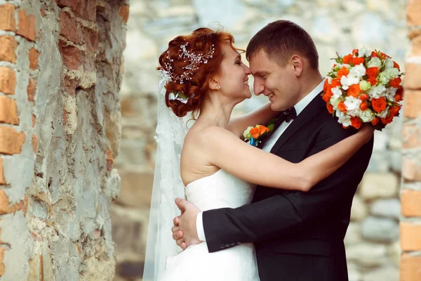 Bräutigam hält Braut Taille zärtlich, während sie seine Stirn küsst — Stockfoto