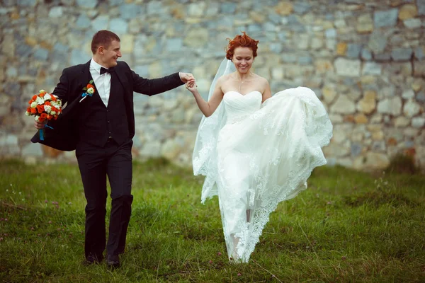 Sposa salta su tenendo la mano dello sposo — Foto Stock