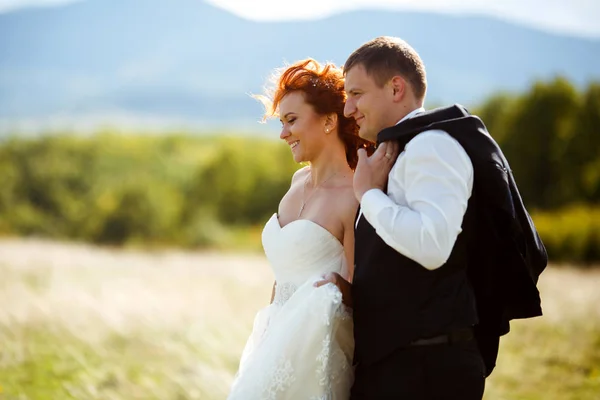 Viento sopla a través del pelo de la novia mientras ella está detrás de un novio — Foto de Stock