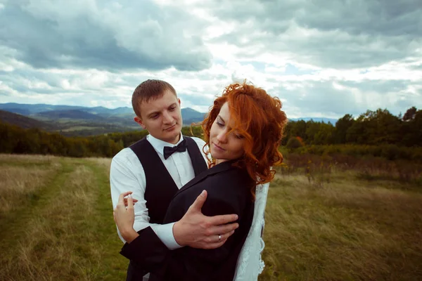 El novio mira a la novia con amor inclinándola, de pie sobre el — Foto de Stock