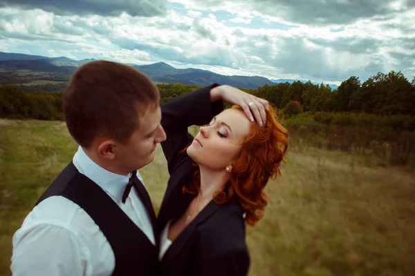 Bride touches her hair throwing her head back standing in groom' — стокове фото