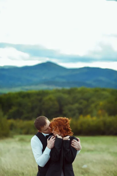 Tierna boda pareja abrazos de pie en el frente de un gran moun — Foto de Stock