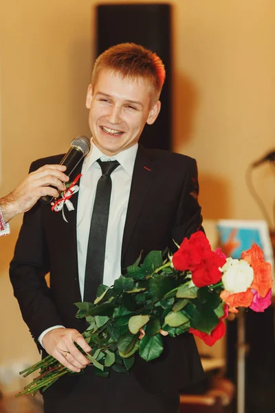 Un homme avec des roses parle dans le micro — Photo