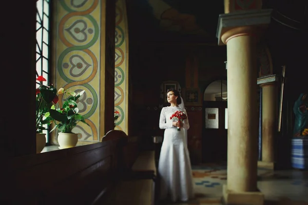 寂寞的新娘站在教堂的长椅后面 — 图库照片