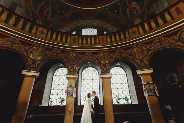 Только что супружеская пара стоит перед окном под папой — стоковое фото