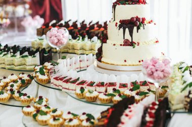 Pembe marsh-mallows cam vazo içinde yalan ve bir düğün etrafında stand