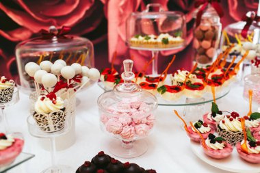 Küçük pembe marsh-mallows arasında farklı bir cam kutusu stand