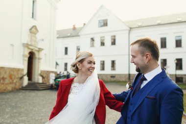 Eski bir arka bahçesinde üzerinde poz bir evlilik çift gülümsüyor 