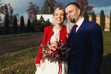 Şık gelin ve damat arka bahçesinde bir gün batımı ayakta keyfini çıkarın 