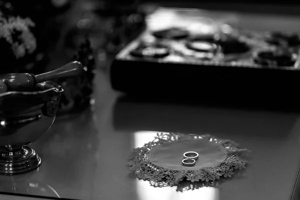 Snubní prsteny leží na stole v kostele — Stock fotografie