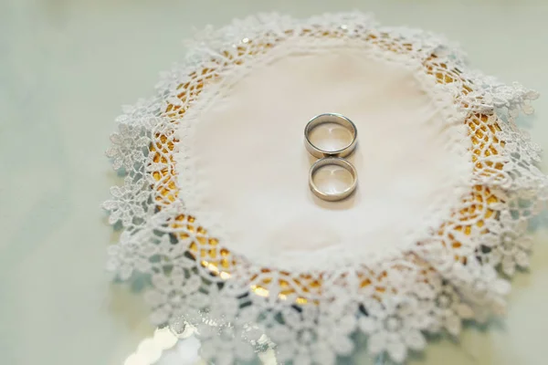 Anillos de boda de oro perfecto se encuentran en una servilleta bordada —  Fotos de Stock