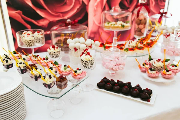 Десерти в шоколаді та білій глазурі стоять на обідньому столі — стокове фото